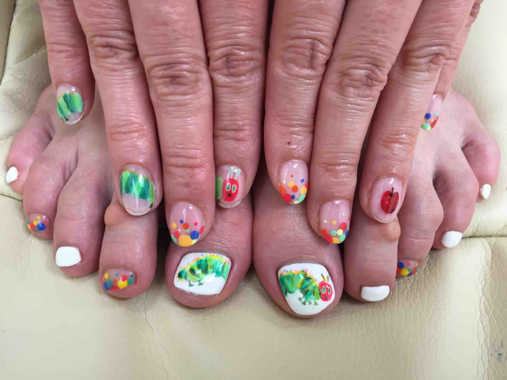 「はらぺこあおむし」（エリック・カール作）のネイル。足はちゃんと見えるように白ベースの上に描いてもらって、手はクリアベースで右手３本にわたって。